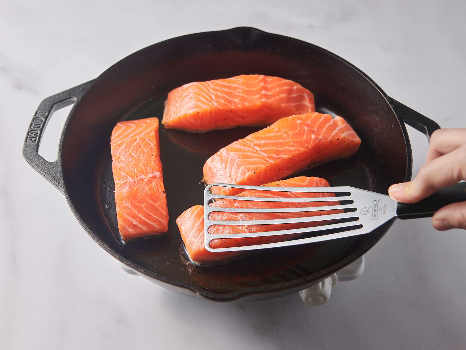 Gently pressing on fillets in pan