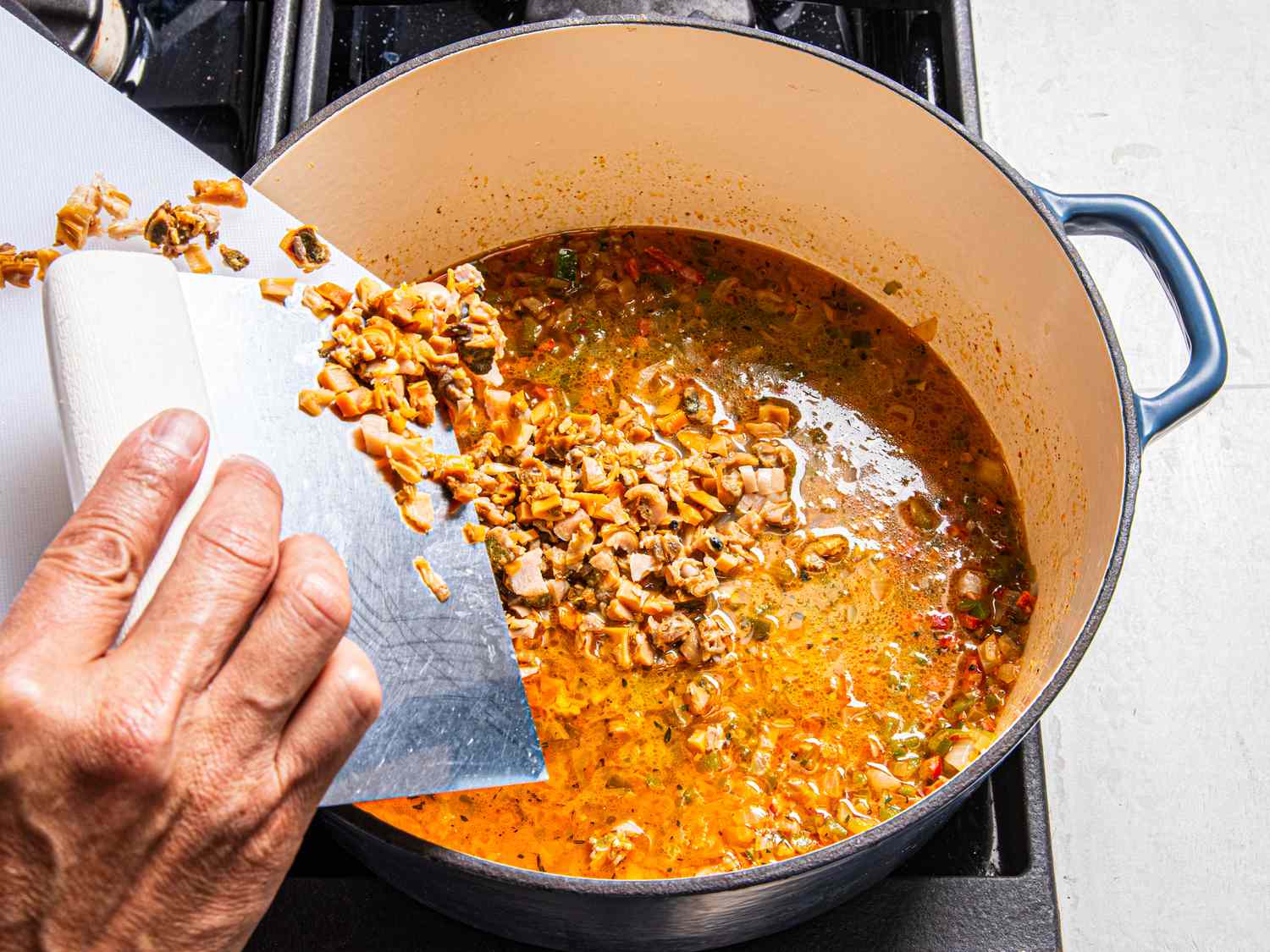 Adding cooked clams back to the pot