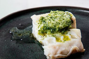 A piece of compound butter melting on a piece of steamed fish