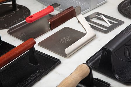 an array of grill presses on a marble surface