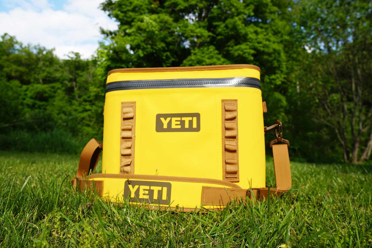 a yellow soft cooler on a grassy surface