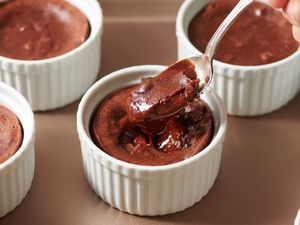 Chocolate lava cake in ramekin, not yet opened up with a spoon