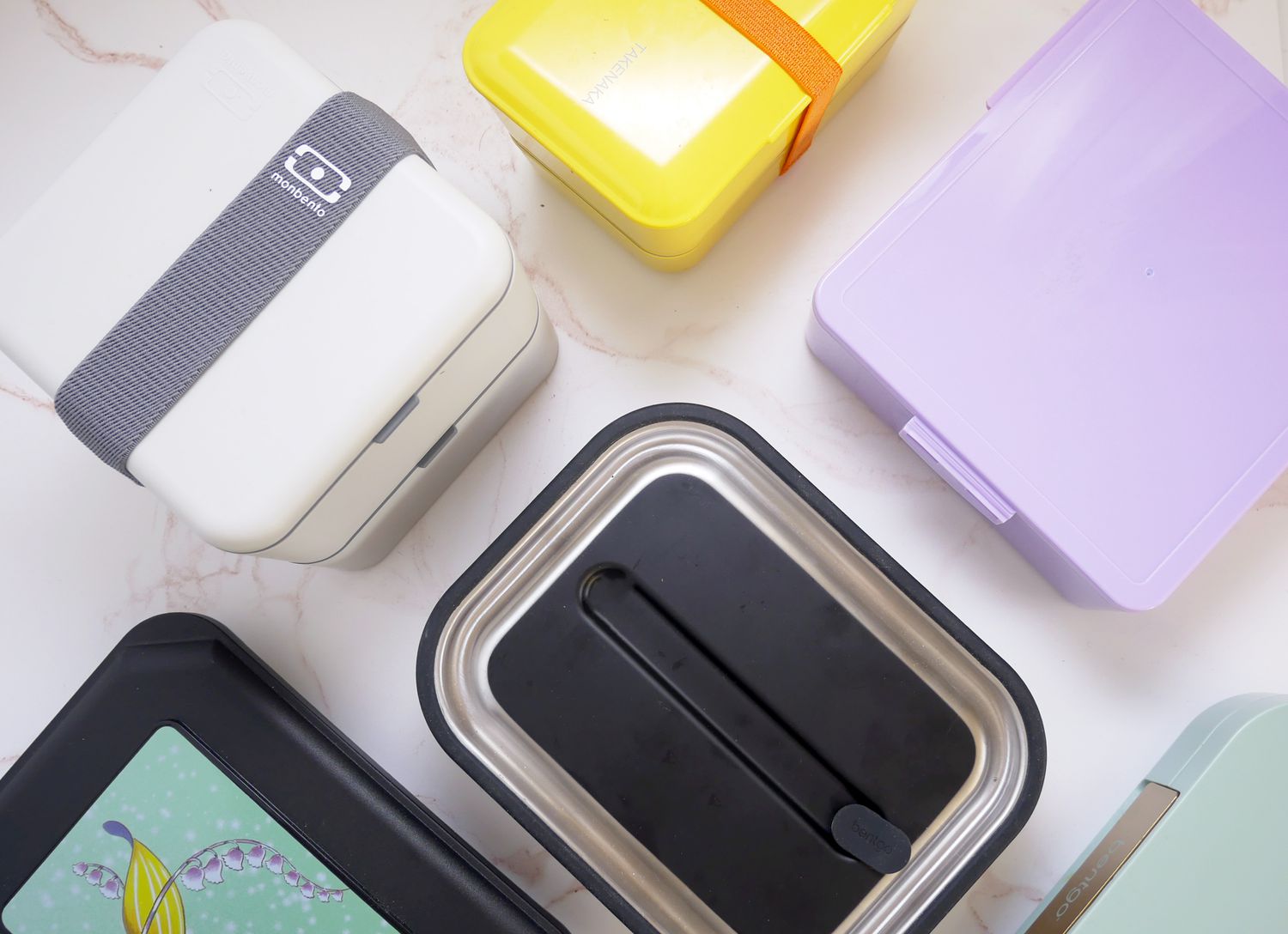 overhead shot of a few bento boxes on a marble countertop