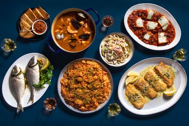 A Feast of the Seven Fishes holiday spread on a blue tablecloth.