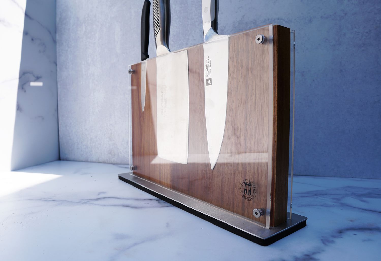 a knife block with three knives affixed to it on a marble surface